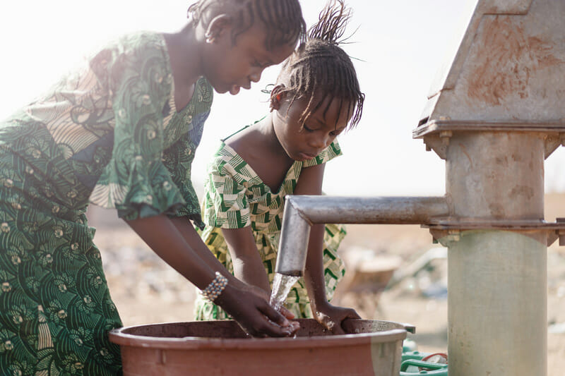 getting-clean-water-2 two Ethiopian girls washing their hands in clean water from a well